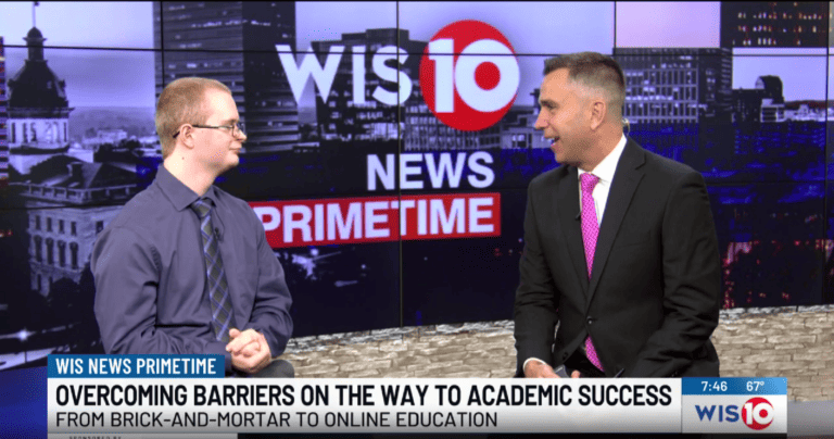 Two men in suits engaged in conversation on a professional news set, surrounded by cameras and broadcasting equipment.