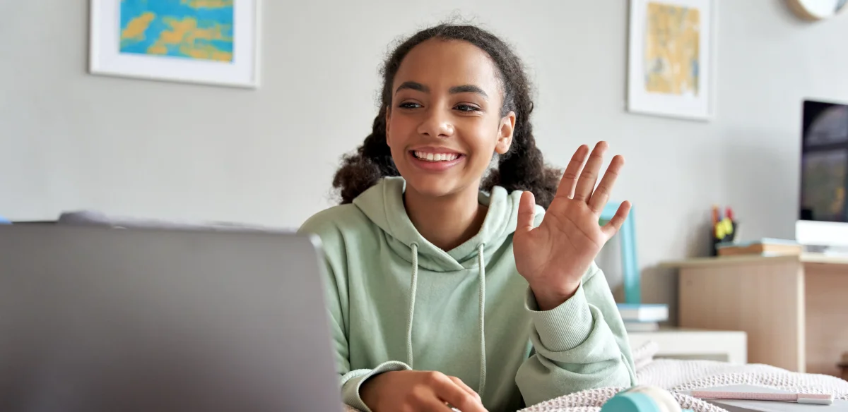 little girl saying hi to the computer camera